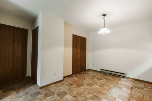 Grand Forks, ND Carling Manor Apartments. a dining room with white walls and a brown tile floor