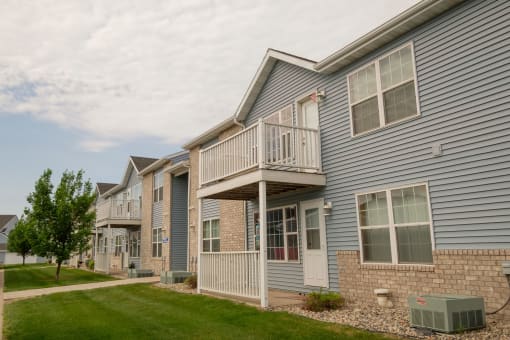 Arow of town homes with balconies and a sidewalk
