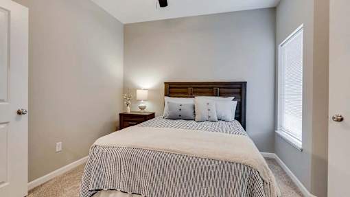 a bedroom with a bed and a window. Circle Pines, MN Lexington Lofts