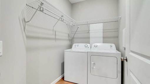 a washer and dryer in a laundry room with a rack on the wall Lexington Lofts