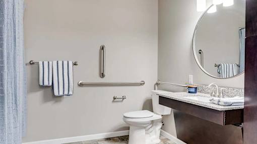 a bathroom with a toilet and a sink and a mirror. Circle Pines, MN Lexington Lofts