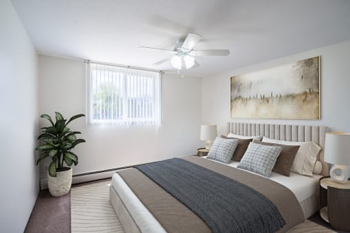 a bedroom with a bed and a ceiling fan. Coon Rapids, MN Robinwood Apartments