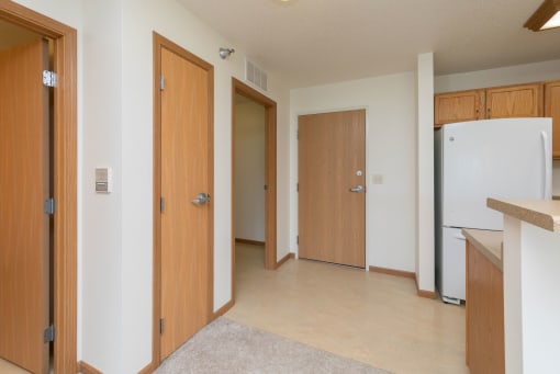 an entryway with a door and kitchen with a closet
