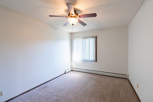 a bedroom of an empty apartment with a ceiling fan.  Eagan, MN Glen Pond Apartments