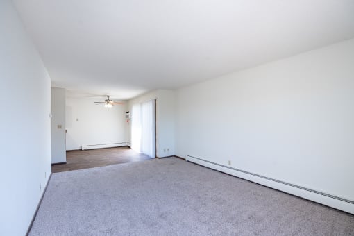 a living room with white walls and carpet and a ceiling fan. Eagan, MN Glen Pond Apartments