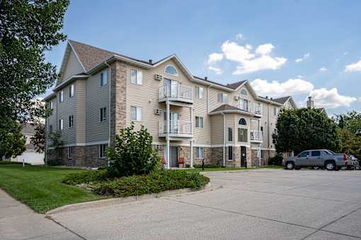 A large apartment complex with a parking lot in front.