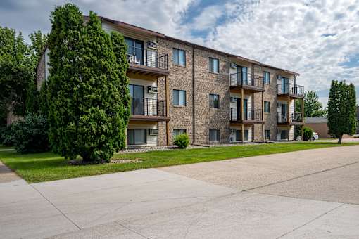 A large apartment complex with a parking lot in front. Fargo, ND Hawthorn Apartments