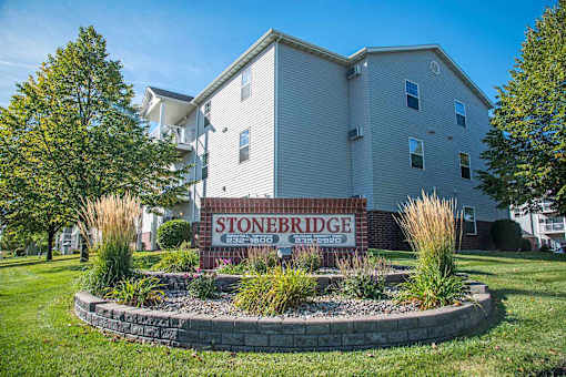 A building with a sign that says Stoneridge in front of it. Fargo, ND Stonebridge Apartments