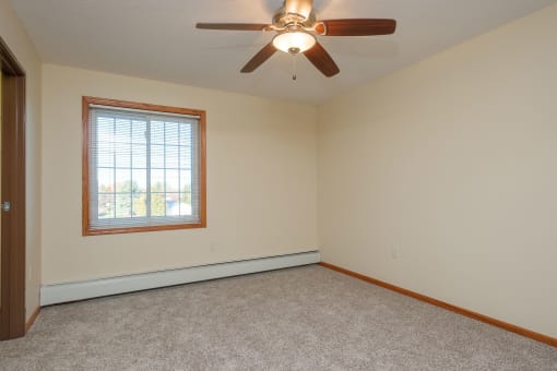 a bedroom with a window. Fargo, ND Crossroads Apartments