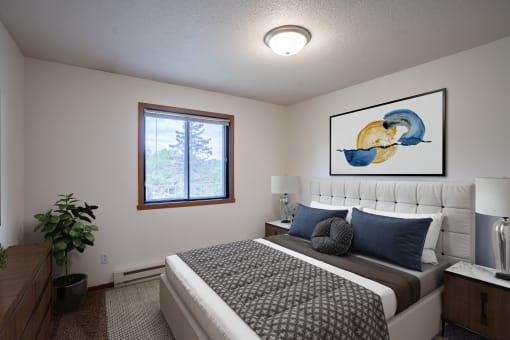 a bedroom with a bed and a painting on the wall. Fargo, ND Briar Pointe Apartments