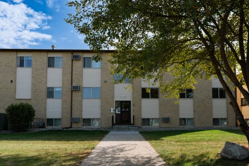 an apartment building with a sidewalk in front of it. Fargo, ND Brookfield Apartments