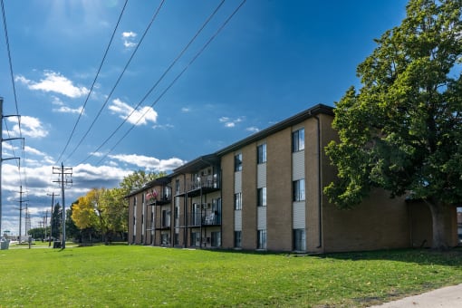 a large brick apartment building with a green grass in front at France, North Dakota