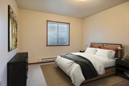 Fargo, ND Oxford Apartments. a bedroom with a bed and a window