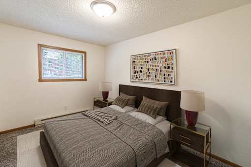 a bedroom with a bed and a window. Fargo, ND Patricia Ann Apartments