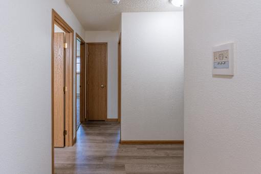 Fargo, ND Patricia Ann Apartments. A hallway with white walls and wood floors