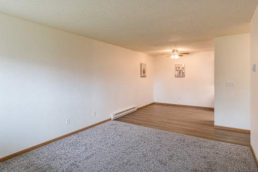 Fargo, ND Patricia Ann Apartments. A living room and dining room with a ceiling fan in the dining room.