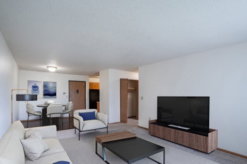 a living room with a couch and a coffee table and a television. Fargo, ND Prairie Park Apartments