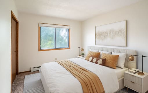a bedroom with a large bed and a window. Fargo, ND Brookfield Apartments