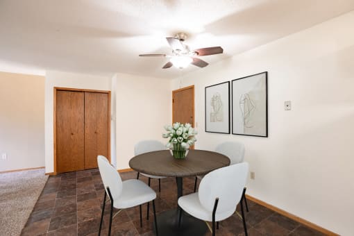 a dining room with a table and chairs and a ceiling fan.Fargo, ND Brookfield Apartments