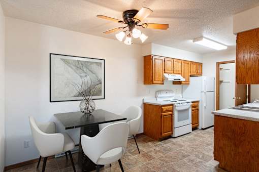 a kitchen and dining room with a table and chairs. Fargo, ND Brownstone Apartments
