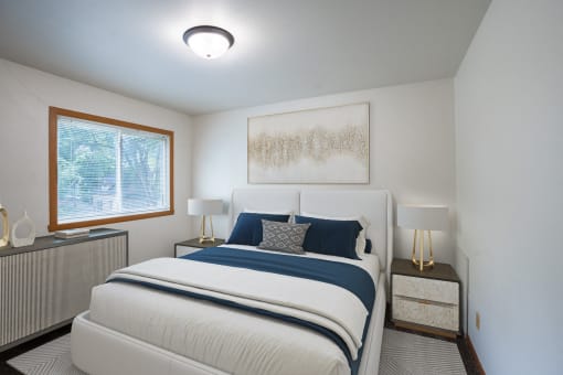 a bedroom with a bed and two night stands and a window. Fargo, ND Crown Court 1 Apartments