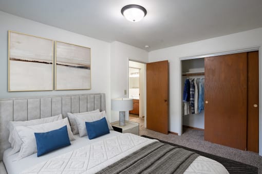 a bedroom with a bed and a closet.Fargo, ND Crown Court 1 Apartments