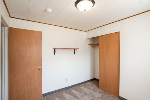 an empty room with a door to a closet. Fargo, ND Forest Avenue Apartments