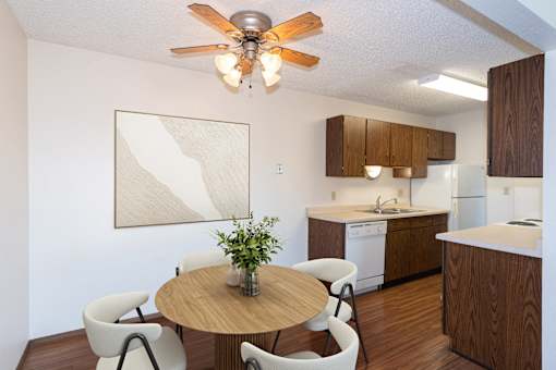 a kitchen and dining room with a table and chairs and a ceiling fan. Fargo, ND Hartford Apartments