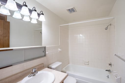 a bathroom with a sink and a bath tub and a mirror, Fargo, ND Hawn Apartments