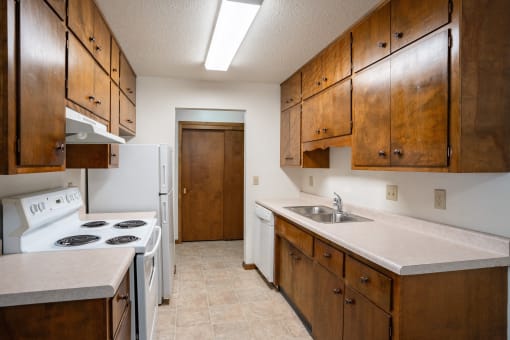 a kitchen with white appliances and wooden cabinets. Fargo, ND Hawn Apartments