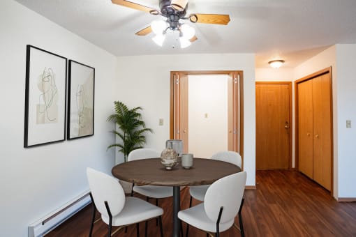 a dining room with a table and chairs and a ceiling fan. Fargo, ND Kentwood Manor Apartments