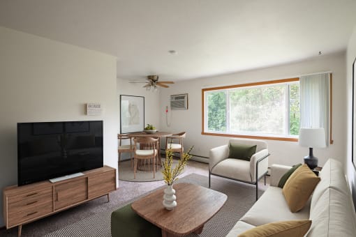 a living room with a couch a chair a table and a television. Fargo, ND Luxford Apartments
