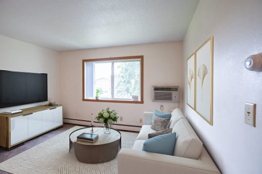 a living room with a couch and a coffee table and a television. Fargo ND Morningside Apartments