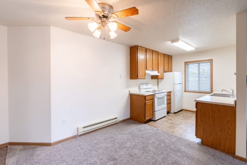 a dining room with a kitchen and a ceiling fan. Fargo, ND Oxford Apartments