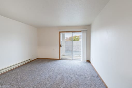 a living room with a glass sliding door. Fargo, ND Oxford Apartments