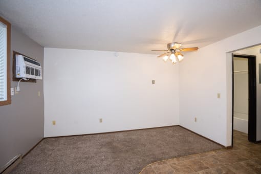 the living room of an empty apartment with a ceiling fan. Fargo, ND Pacific Park 2