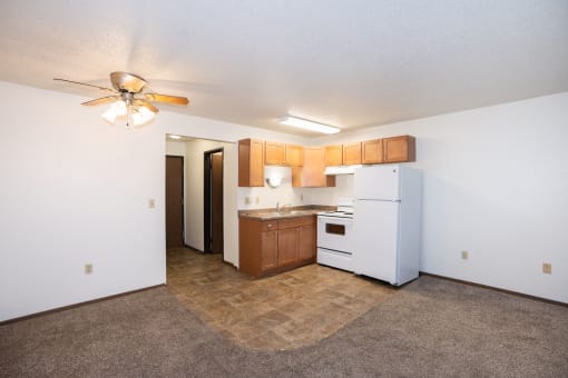 a kitchen with white appliances and wooden cabinets and a ceiling fan. Fargo, ND Pacific Park 2