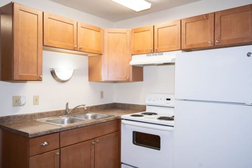 a kitchen with white appliances and wooden cabinets. Fargo, ND Pacific Park 2