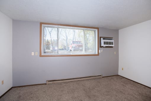 an empty living room with a window and a microwave. Fargo, ND Pacific Park 2