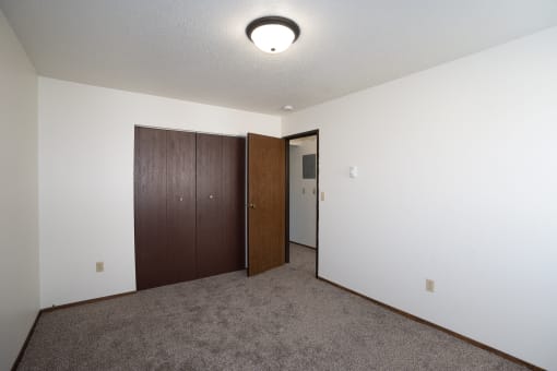 a bedroom with a closet and a door to a hallway. Fargo, ND Pacific Park 2