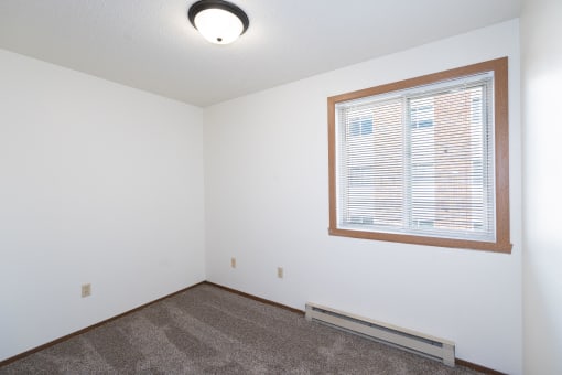 an empty room with a large window and carpet. Fargo, ND Pacific Park 2