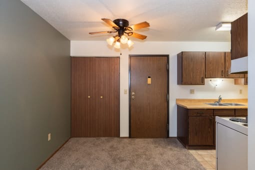 an empty kitchen with a ceiling fan and a door to a closet. Fargo, ND Pacific Park 2