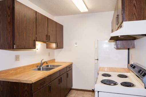 a kitchen with a stove sink and refrigerator. Fargo, ND Pacific Park 2