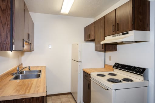an empty kitchen with a stove refrigerator and sink. Fargo, ND Pacific Park 2