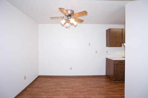a dining room with a ceiling fan and a kitchen. Fargo, ND Pacific Park Apartments