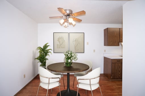 a dining room with a table and chairs and a ceiling fan. Fargo, ND Pacific Park Apartments