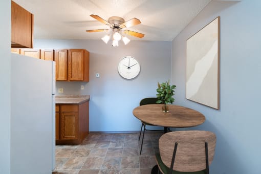 a dining room with a table and a clock on the wall. Fargo, ND Pacific Park Apartments