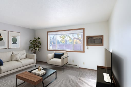 a living room with a couch and a table and a window. Fargo, ND Pacific Park Apartments