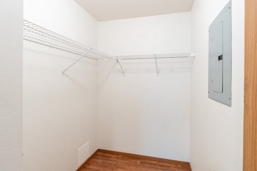 an empty closet with a metal rack on the wall and a wood floor. Fargo, ND Rosegate Apartments