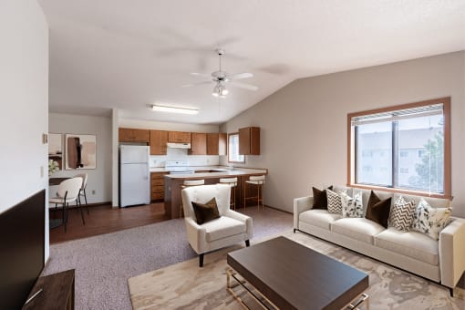 a living room and kitchen with a couch and a table. Fargo, ND Rosegate Apartments